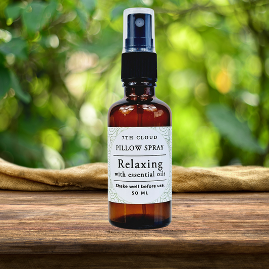 Bottle of 7th Cloud Pillow Spray on a wooden surface with a green blurred background