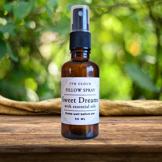 Bottle of 'Sweet Dreams' pillow spray on a wooden surface with a natural background