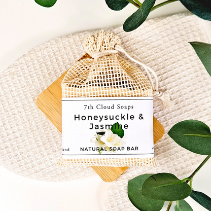 Honeysuckle & Jasmine soap bar from 7th Cloud Soaps on a textured surface with green leaves.