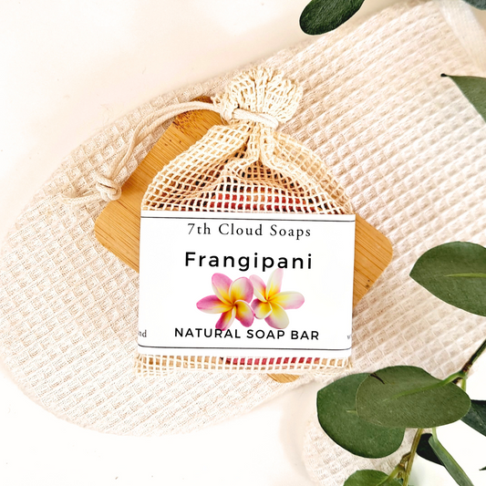 Frangipani natural soap bar in a drawstring bag with a label on a textured fabric background.